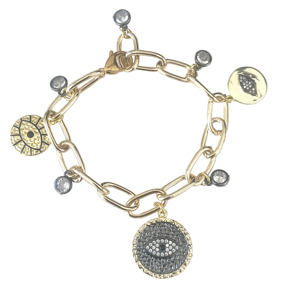 Gold bracelet with various charms on a textured surface