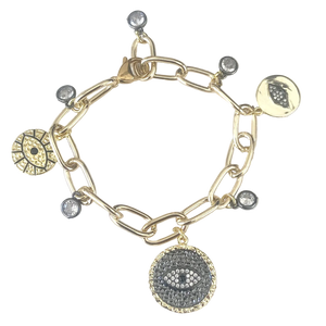 Gold bracelet with various charms on a textured surface