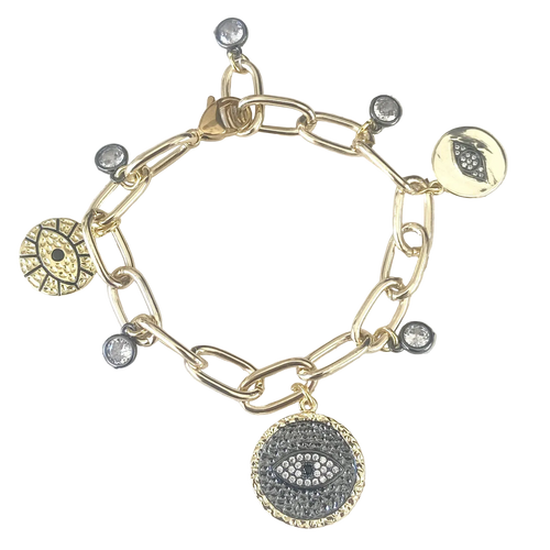 Gold bracelet with various charms on a textured surface