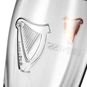 Close-up of a glass with a harp emblem and 'Fost 1759' text.
