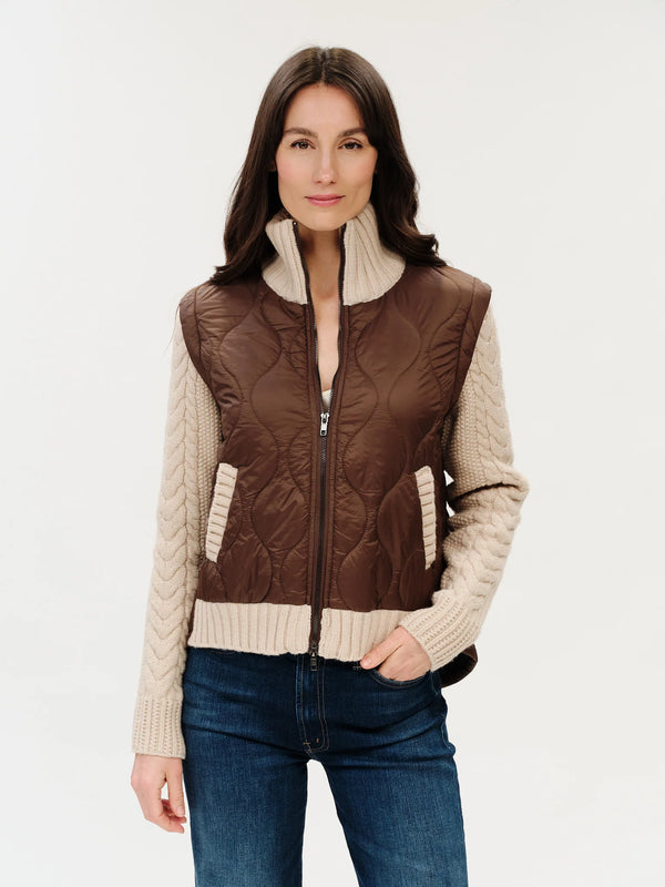 Woman wearing a brown quilted vest over a cream sweater on a white background