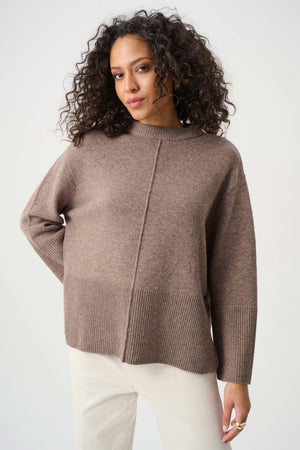 Woman wearing a brown sweater against a white background