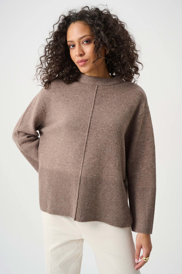 Woman wearing a brown sweater against a white background
