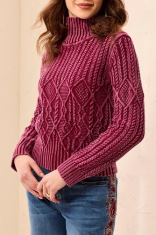 Person wearing a pink knitted sweater with a beige background