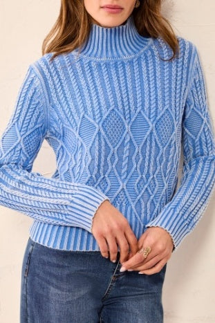 Person wearing a blue patterned sweater against a neutral background