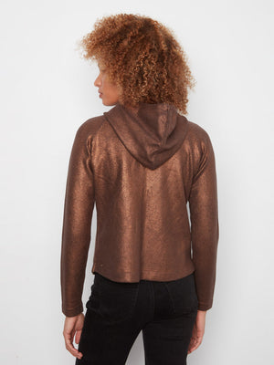 A person shown from the back wearing a metallic bronze cropped hoodie with black pants, photographed against a plain light gray studio background.