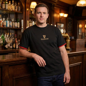 Man wearing a black Guinness t-shirt in a bar setting