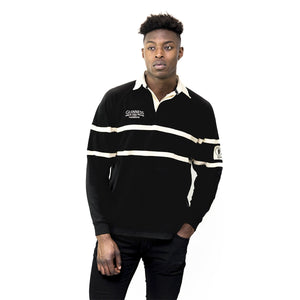 A man modeling a black long-sleeve rugby shirt with cream horizontal stripes and 'Guinness' branding on the chest, set against a plain white background.