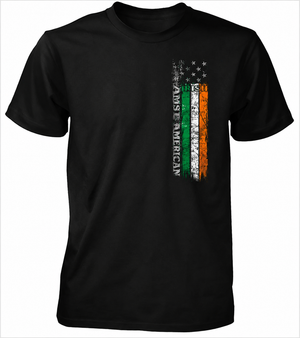 A black short-sleeve crewneck t-shirt featuring a distressed vertical graphic on the left chest. The graphic combines the American flag with the Irish tricolor and the text 'AN AMERICAN IS AN AMERICAN' running vertically.