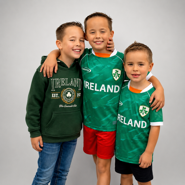 Three young boys standing together and smiling, wearing Ireland soccer-themed apparel. The boy on the left wears a dark green hoodie with 'IRELAND EST.