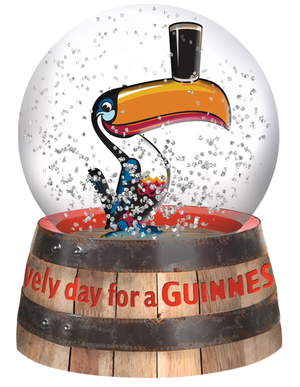 Snow globe with a toucan character and 'Every day for a Guiness' text on a wooden barrel base.