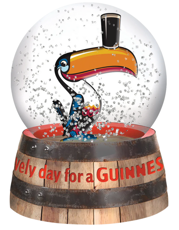 Snow globe with a toucan character and 'Every day for a Guiness' text on a wooden barrel base.