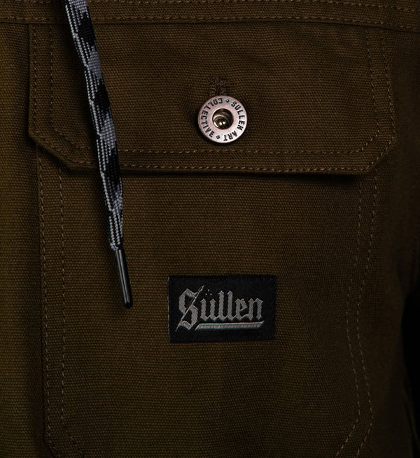 Close-up of a brown jacket with a button and 'Sullen' logo patch.